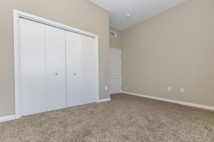 Unfurnished bedroom with closed closet doors