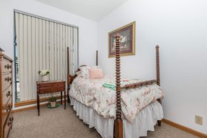 a bedroom with a bed and a chair in a room