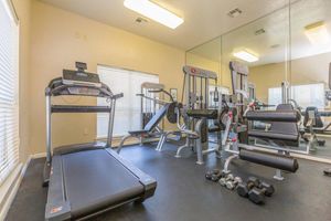 Fitness center with quality equipment in front of mirror in The Avenue apartments for rent