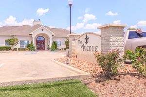 The Avenue entrance sign in front of wide parking spaces for apartment resident use in Nederland