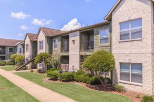 Exterior view of residential buildings with beautiful landscaped grounds at The Avenue apartments