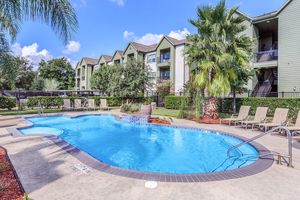 Shimmering outdoor swimming pool with lounge chairs at The Avenue apartments