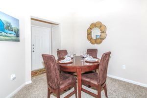 Apartment dining area with four wine glasses and place settings