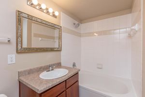 Bathroom with single sink, vanity, and shower/tub combo 