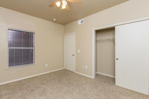 Bedroom with carpeted floors, walk-in closet, and ceiling fan