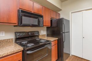 Black refrigerator, microwave and electric stove in galley-style kitchen at The Avenue