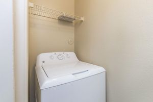Laundry closet with full-size washer/dryer and shelf for extra storage