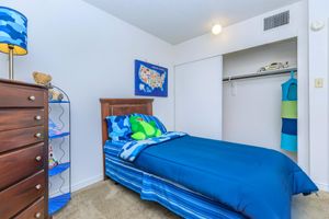 a bedroom with a bed and a blue suitcase