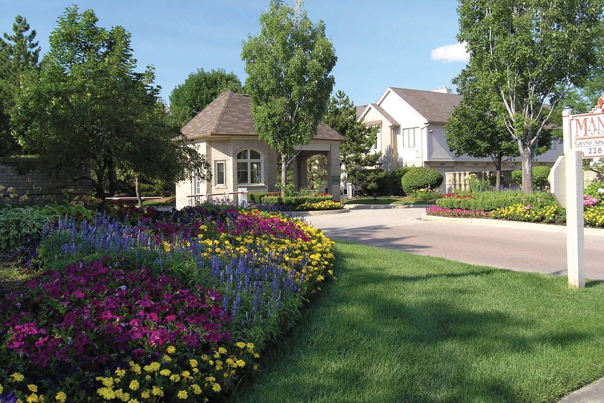 a close up of a flower garden in front of a house