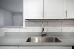 Large sink nestled into grey quartz counter tops